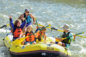 a group of people riding on the back of a boat in the water