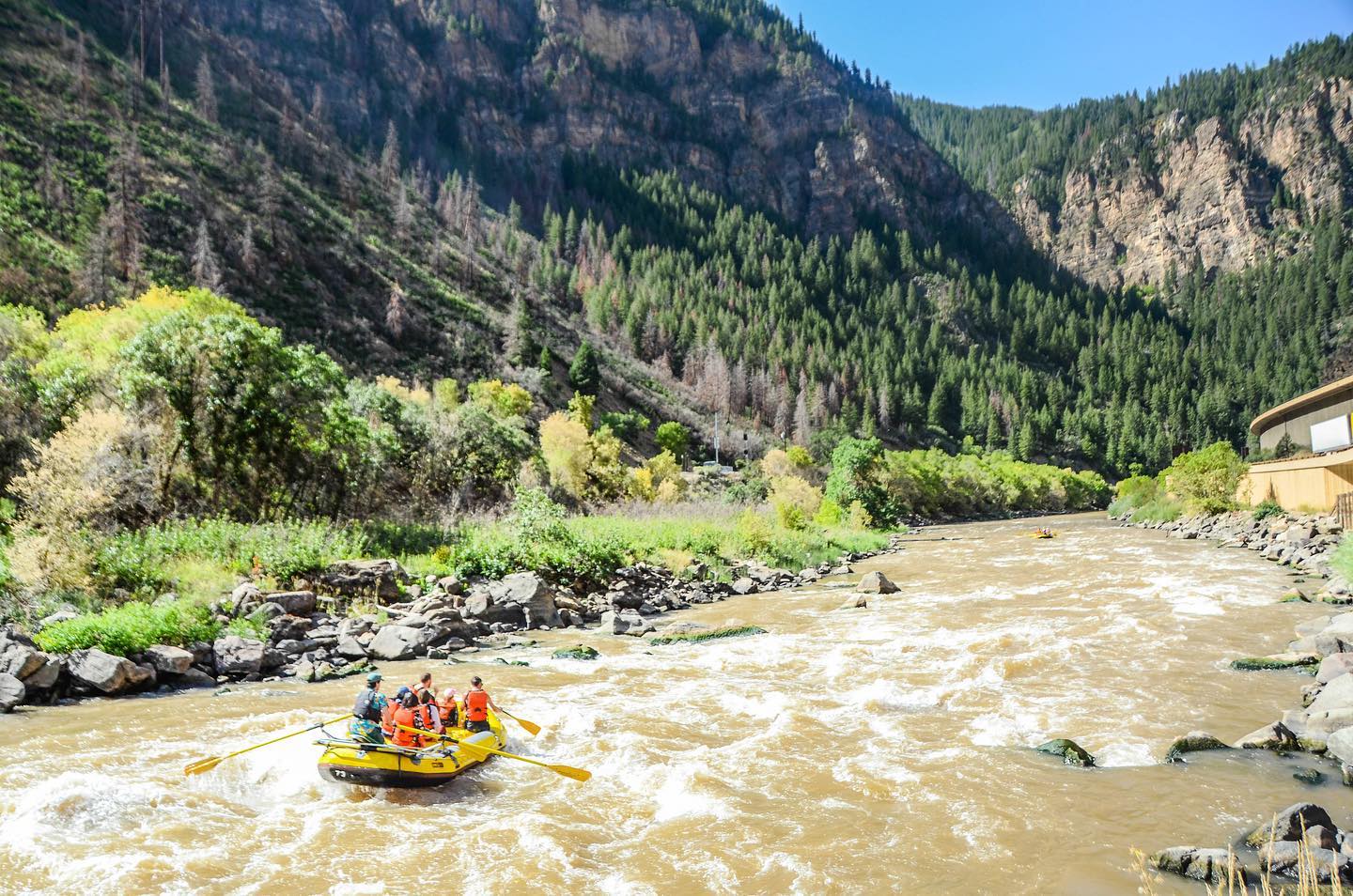 302144172_5554391081248781_2496931842539678573_n a raft next to a body of water with a mountain in the background