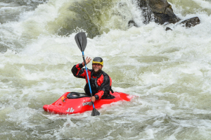 a man riding a wave on a raft in a body of water