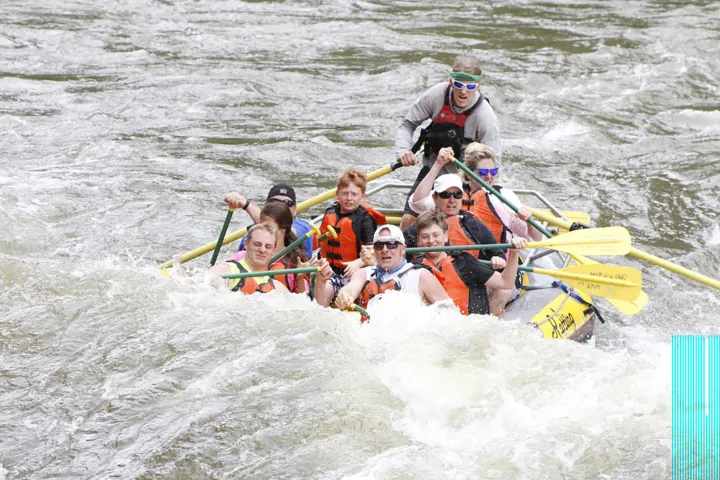 a group of people riding skis on a raft in a body of water