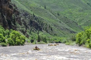 a small boat in a body of water with a mountain in the background