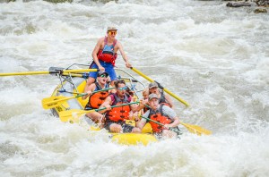 a man riding a wave on a raft in a body of water