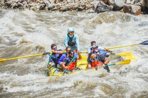a group of people riding skis on a raft in the water